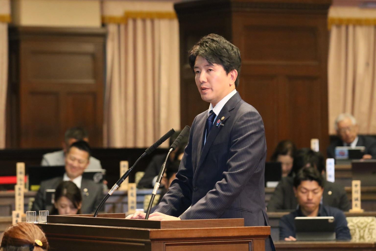 大阪府議会本会議の演壇で質問する坂元正幸